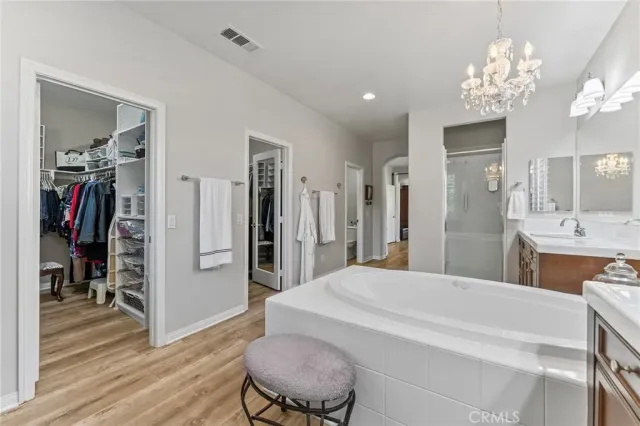 a spacious bedroom with a bed and a chandelier