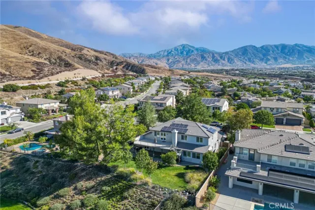 an aerial view of residential houses with outdoor space and trees