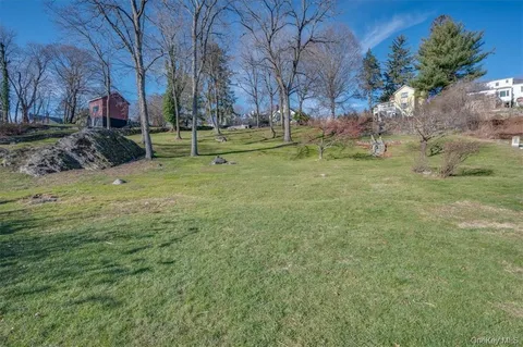 an aerial view of residential houses with outdoor space and trees