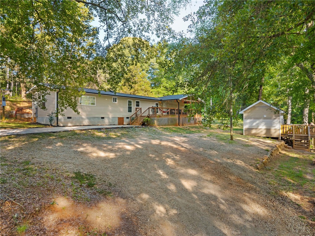 217 Old River Road Pelzer, SC 29669 - Photo 1 of 30 A well-maintained residence sits nestled among mature trees, featuring a spacious porch and a convenient detached shed.
