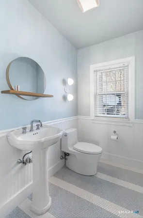 a bathroom with a sink toilet and a mirror