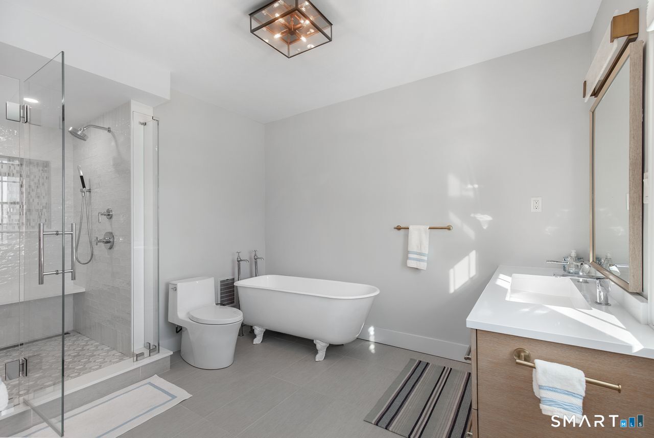 35 Point Lookout Milford, CT 06460 - Photo 22 of 31 A serene, remodeled bathroom featuring a glass-enclosed shower, freestanding soaking tub, and modern vanity with clean lines and warm finishes designed for comfort, style, and everyday luxury.