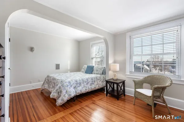a bedroom with a bed and wooden floor