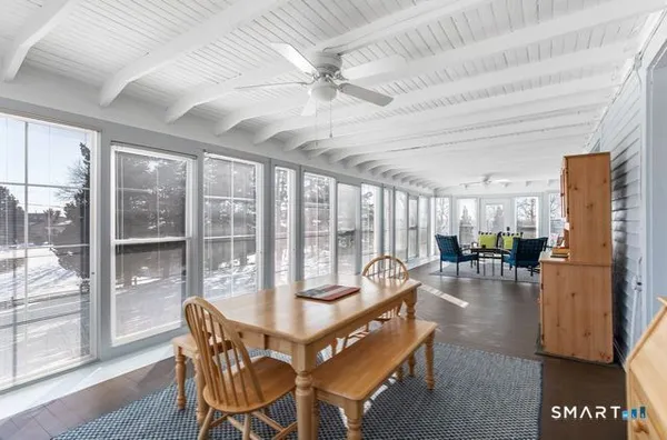 a dining room with furniture water view and a floor to ceiling window