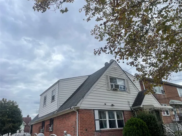 a front view of a house with a tree