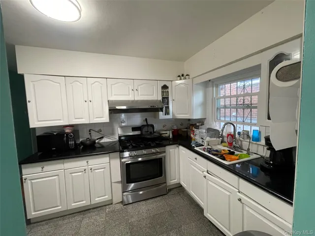 a kitchen with stainless steel appliances a stove a sink and cabinets
