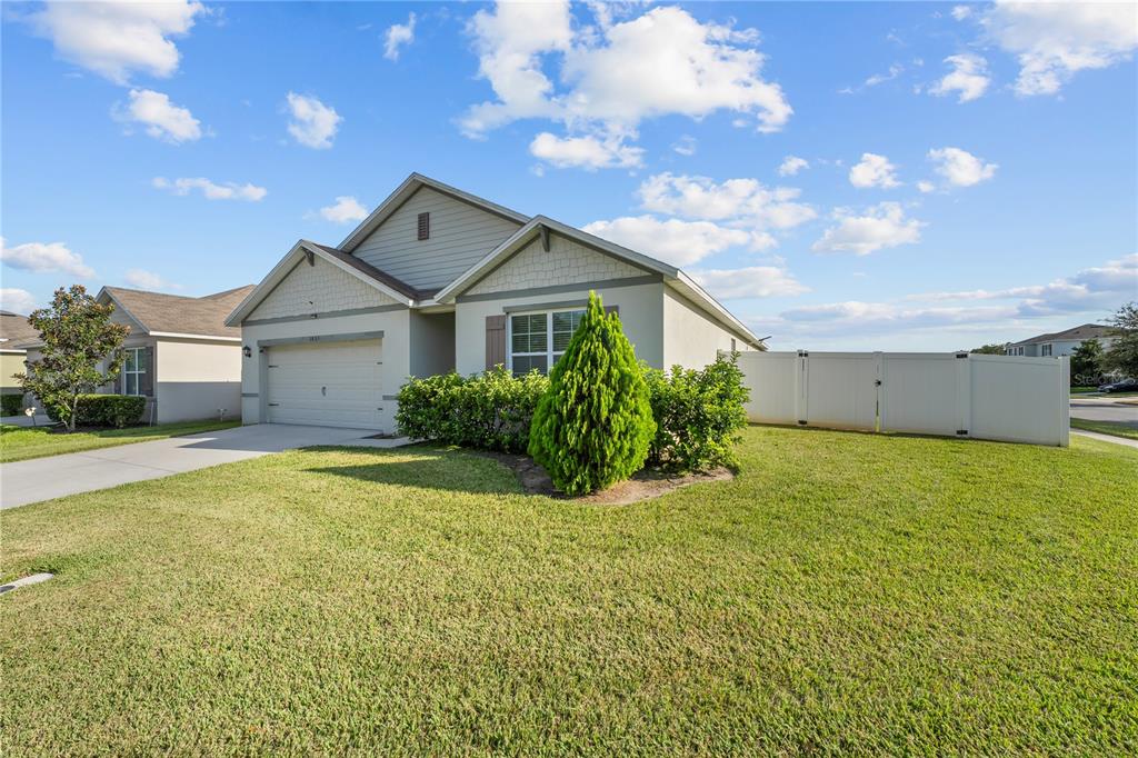 1833 Bluepoint Street St. Cloud, FL 34771 - Photo 11 of 46 a front view of house with yard and trees in the background