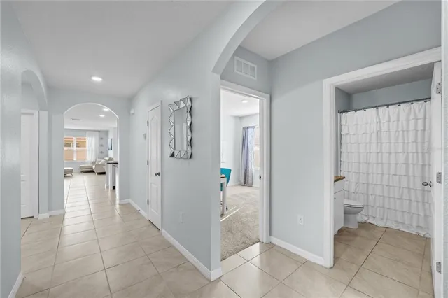a view of a hallway with bathroom and glass door space