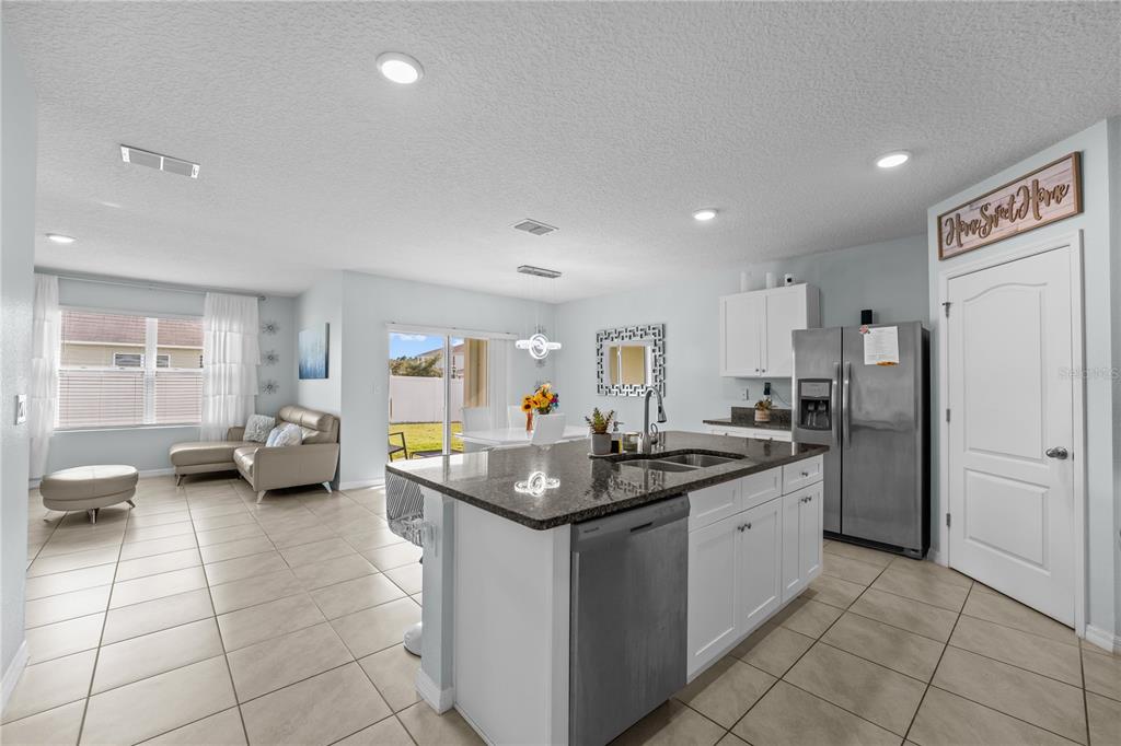 1833 Bluepoint Street St. Cloud, FL 34771 - Photo 14 of 46 a kitchen with stainless steel appliances granite countertop a sink counter space and a view of living room