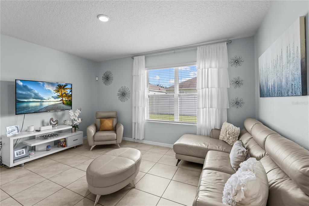 1833 Bluepoint Street St. Cloud, FL 34771 - Photo 15 of 46 a living room with furniture and a flat screen tv