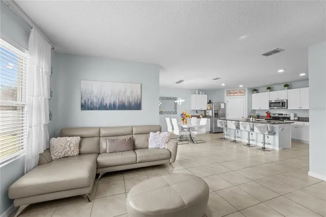 a living room with furniture and kitchen view