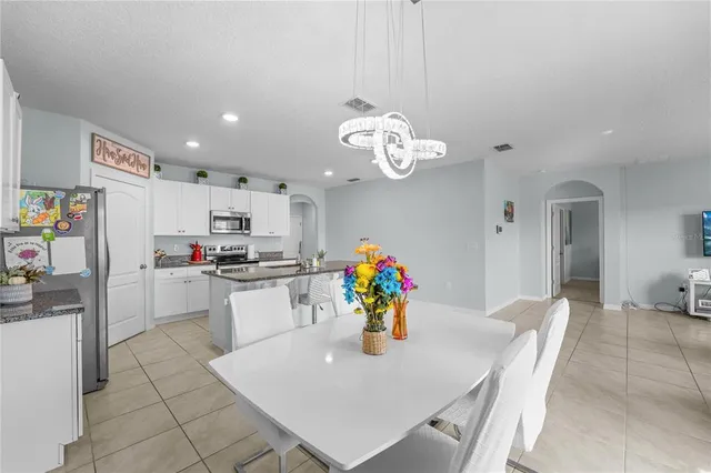 a kitchen with stainless steel appliances granite countertop a sink dishwasher and a refrigerator with wooden floor
