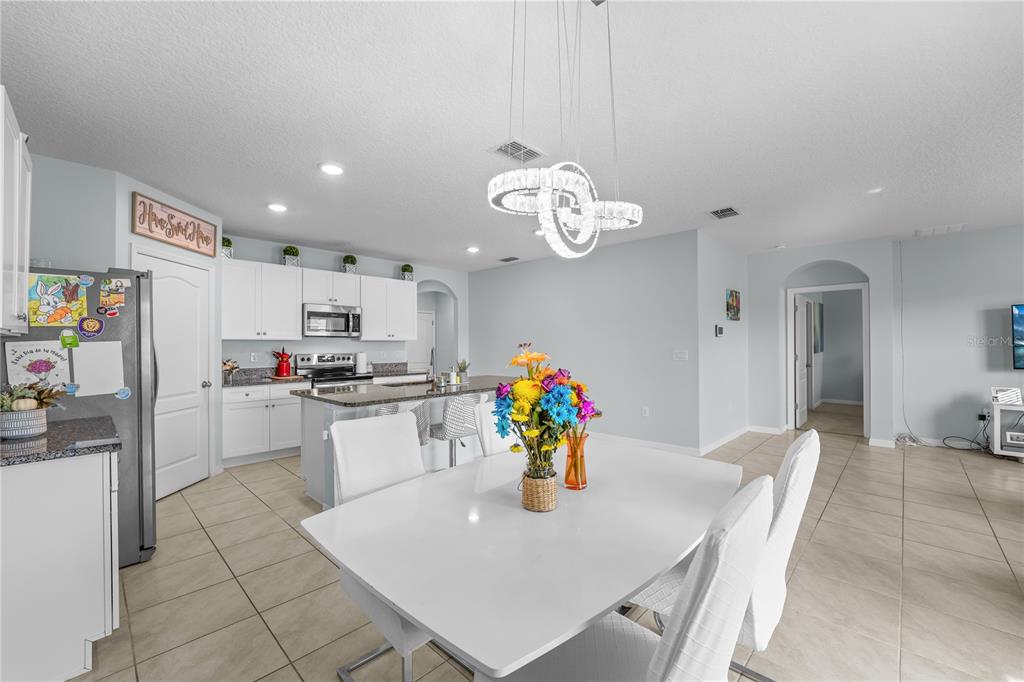 1833 Bluepoint Street St. Cloud, FL 34771 - Photo 26 of 46 a kitchen with stainless steel appliances granite countertop a sink dishwasher and a refrigerator with wooden floor