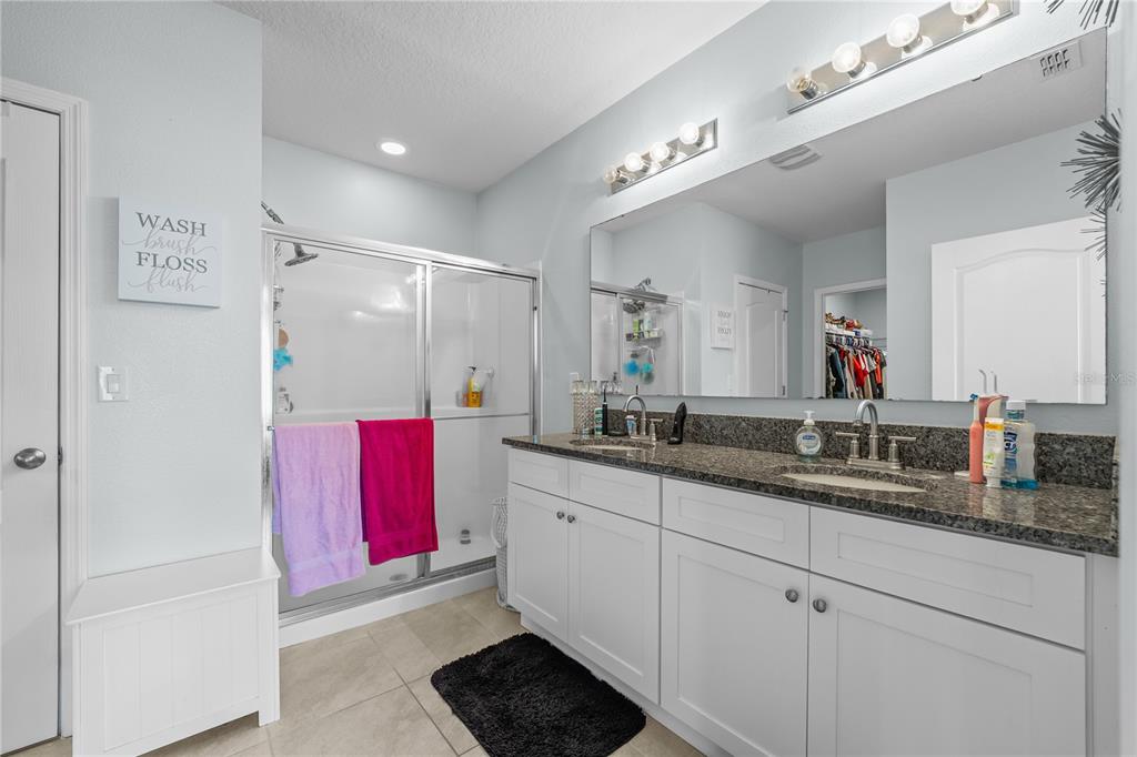 1833 Bluepoint Street St. Cloud, FL 34771 - Photo 32 of 46 a bathroom with a double vanity sink and a mirror