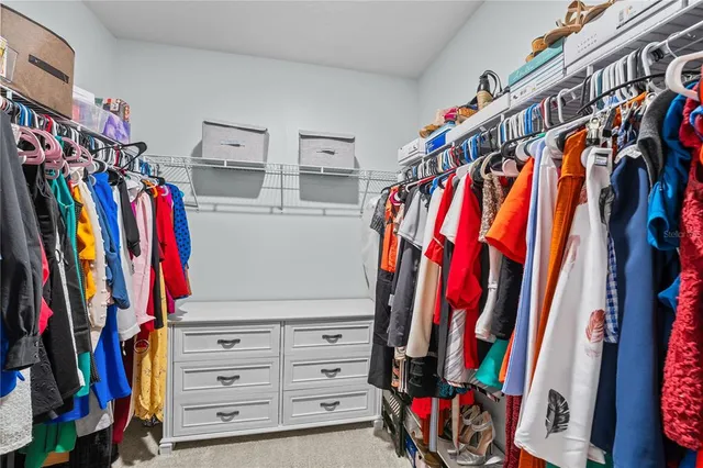 a view of walk in closet with clothes