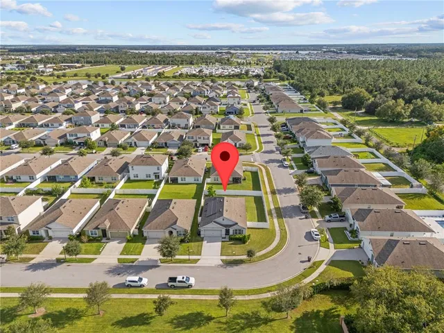 an aerial view of residential houses with outdoor space and ocean view