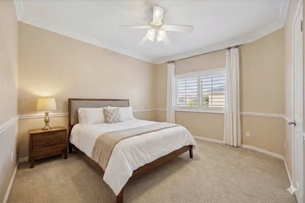 a bedroom with a bed and a ceiling fan