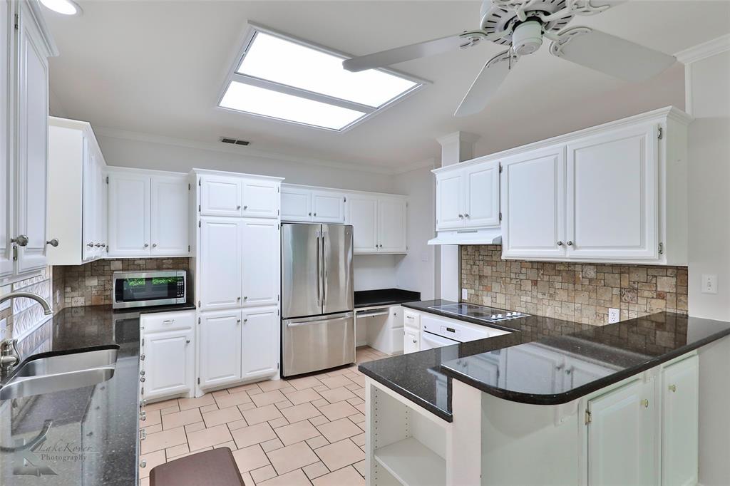 106 Riverside Park Abilene, TX 79605 - Photo 12 of 40 a kitchen with granite countertop a sink stainless steel appliances and white cabinets