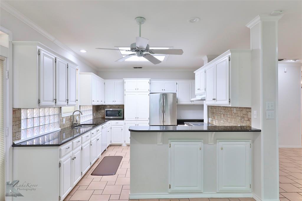 106 Riverside Park Abilene, TX 79605 - Photo 13 of 40 a kitchen with kitchen island granite countertop a sink cabinets and stainless steel appliances