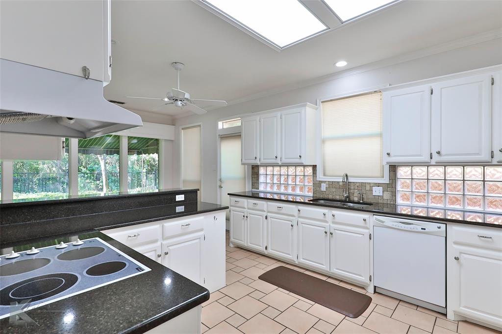 106 Riverside Park Abilene, TX 79605 - Photo 9 of 40 a kitchen with granite countertop a sink window and cabinets