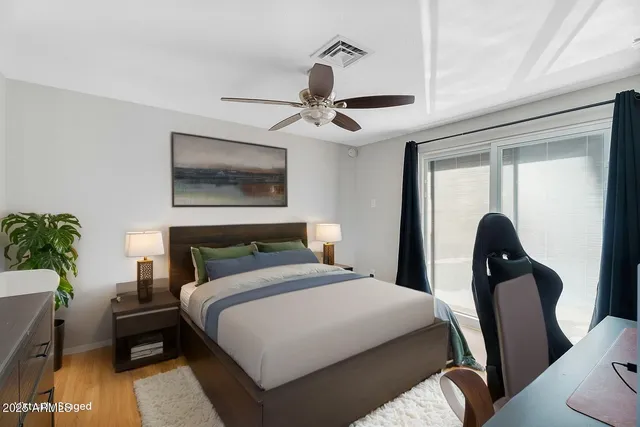a bedroom with a bed a chandelier and a potted plant