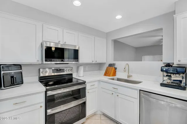 a kitchen with appliances a sink and cabinets