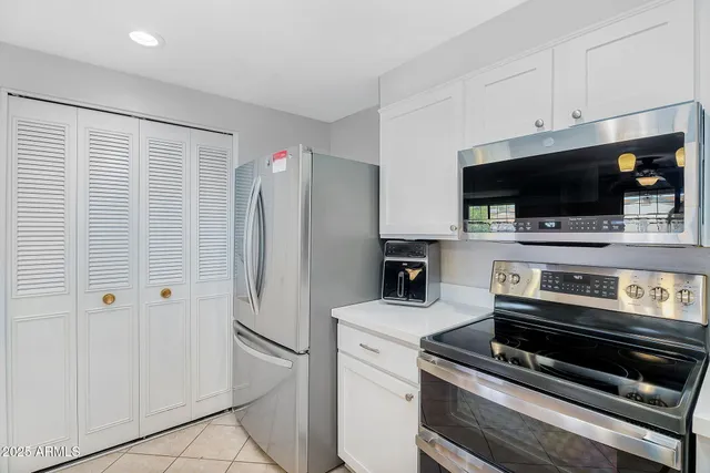 a kitchen with a refrigerator and a stove top oven
