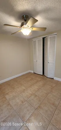 a view of a livingroom with a chandelier fan and windows