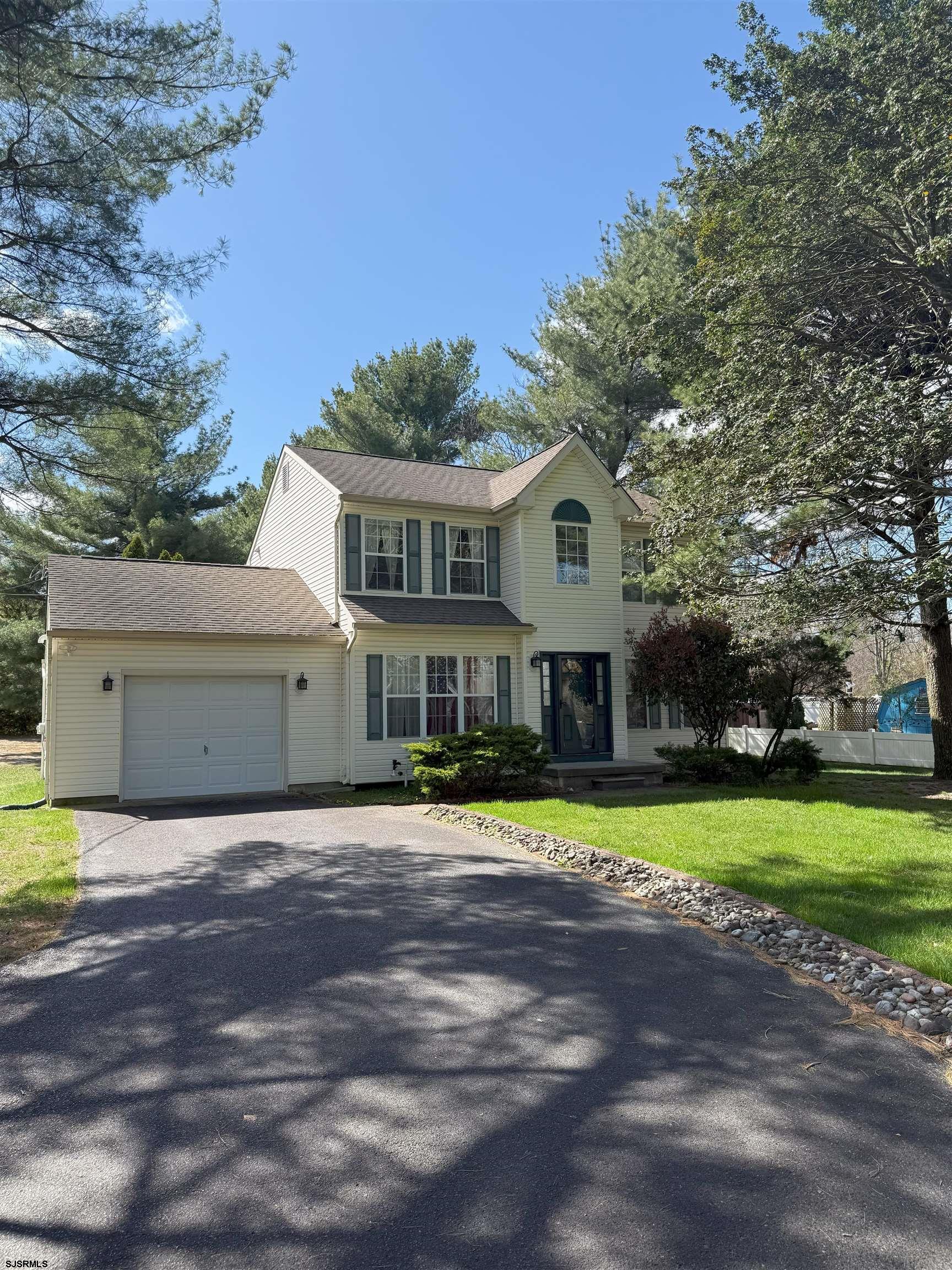 a front view of a house with a yard and trees