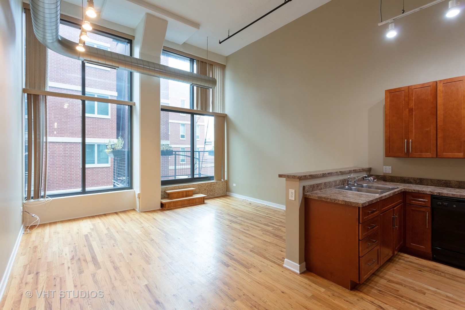 1224 West Van Buren Street, Unit 217 Chicago, IL 60607 - Photo 2 of 16 a view of a room with wooden floor and windows