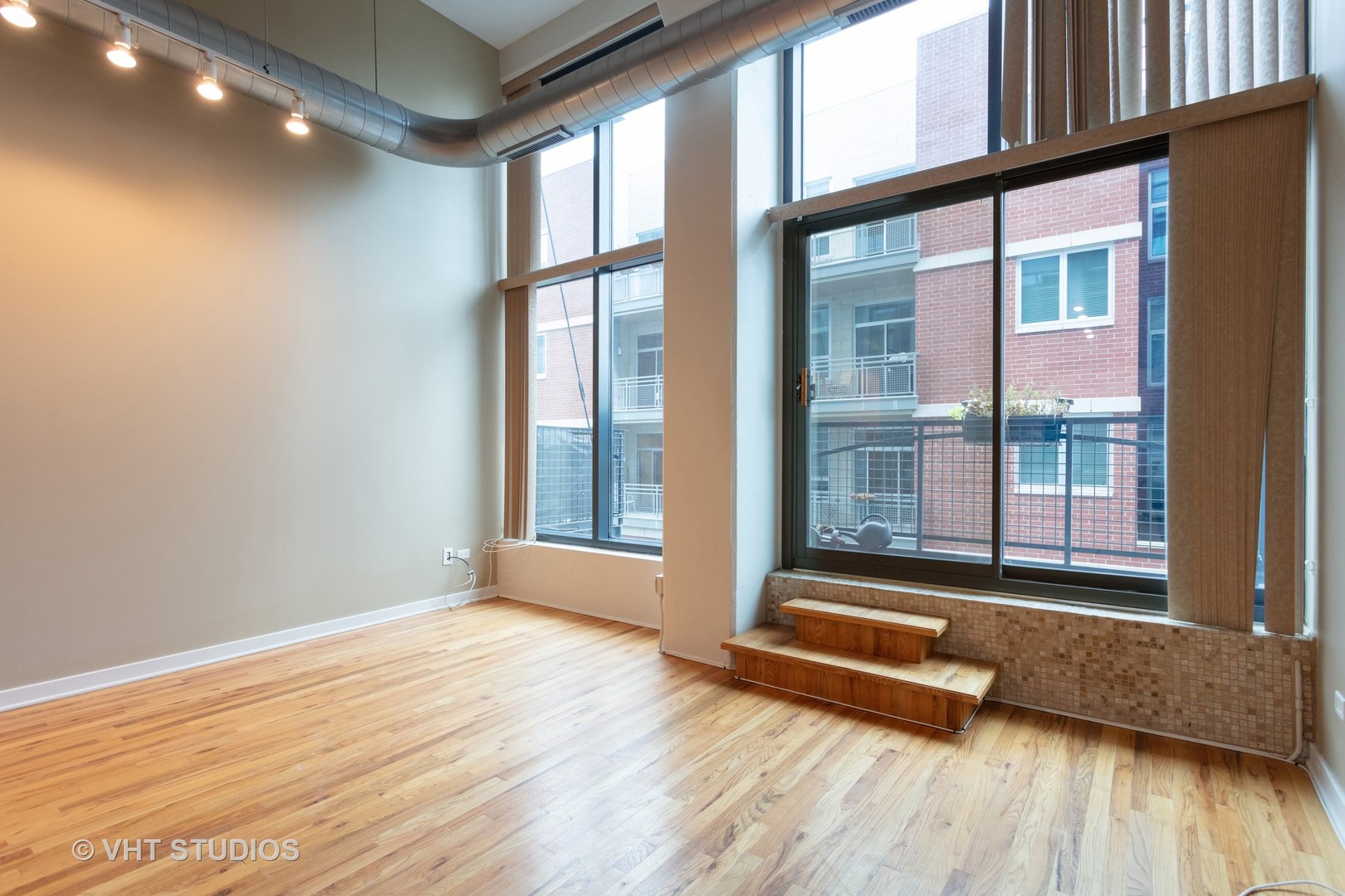 1224 West Van Buren Street, Unit 217 Chicago, IL 60607 - Photo 16 of 16 a view of an empty room with wooden floor and a window