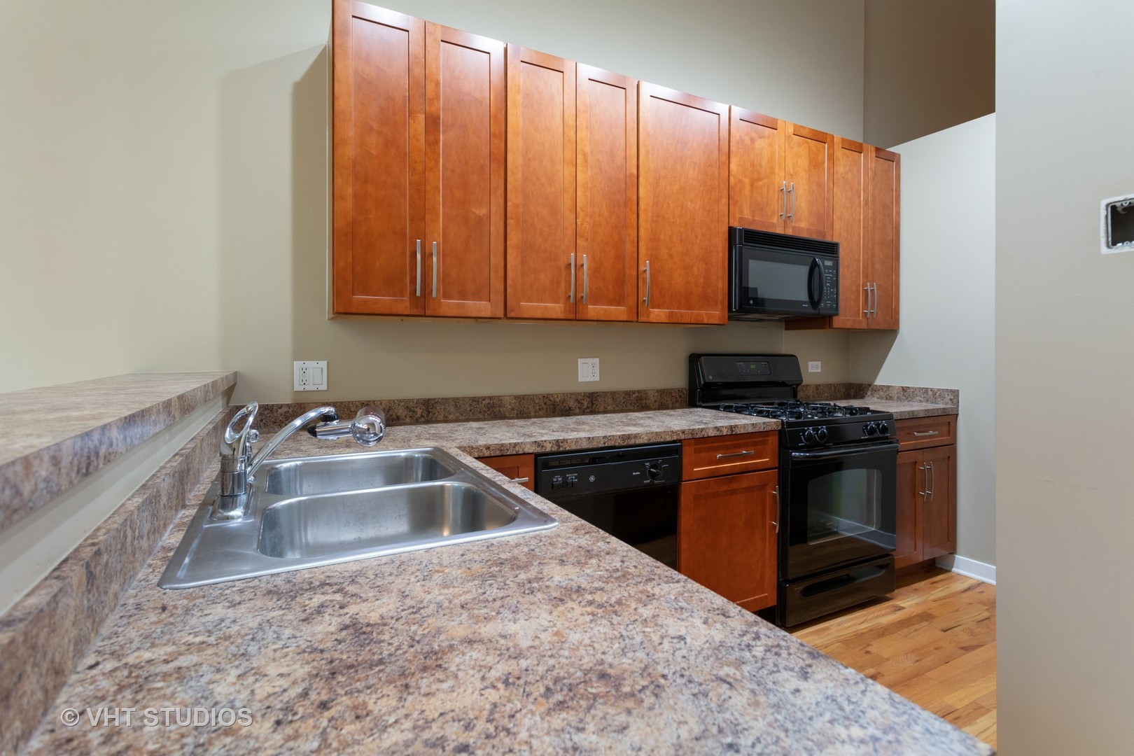 1224 West Van Buren Street, Unit 217 Chicago, IL 60607 - Photo 4 of 16 a kitchen with a sink stove and microwave