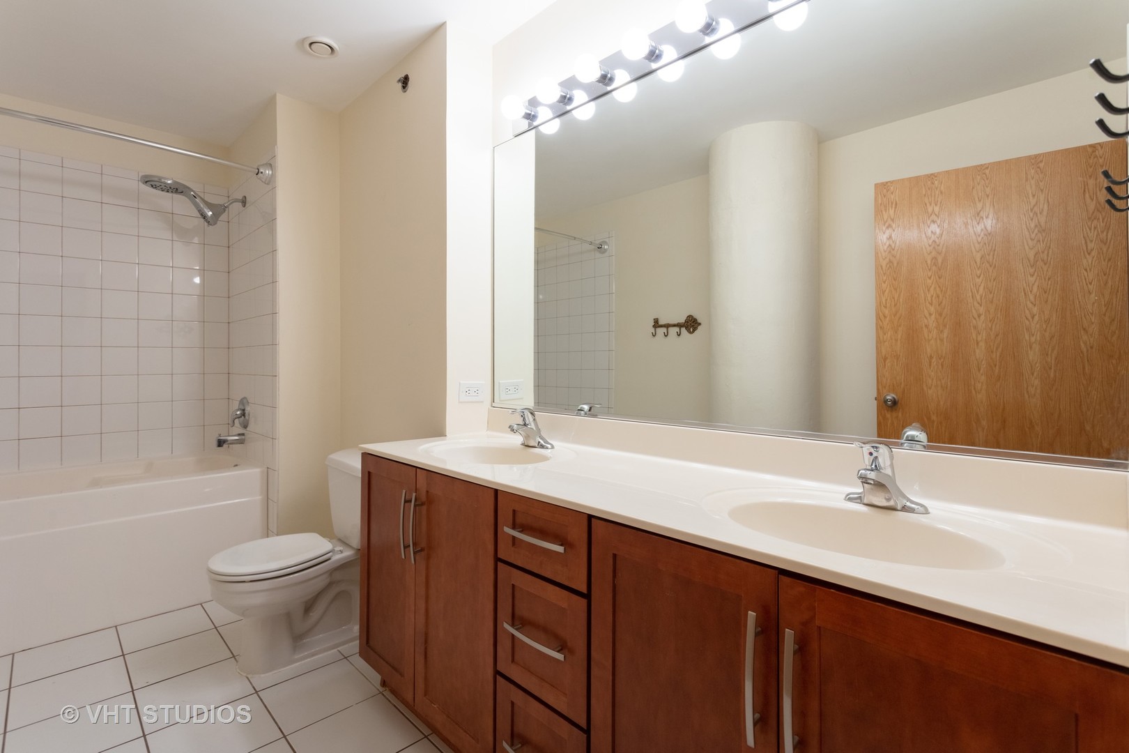 1224 West Van Buren Street, Unit 217 Chicago, IL 60607 - Photo 7 of 16 a bathroom with a double vanity sink toilet mirror and shower