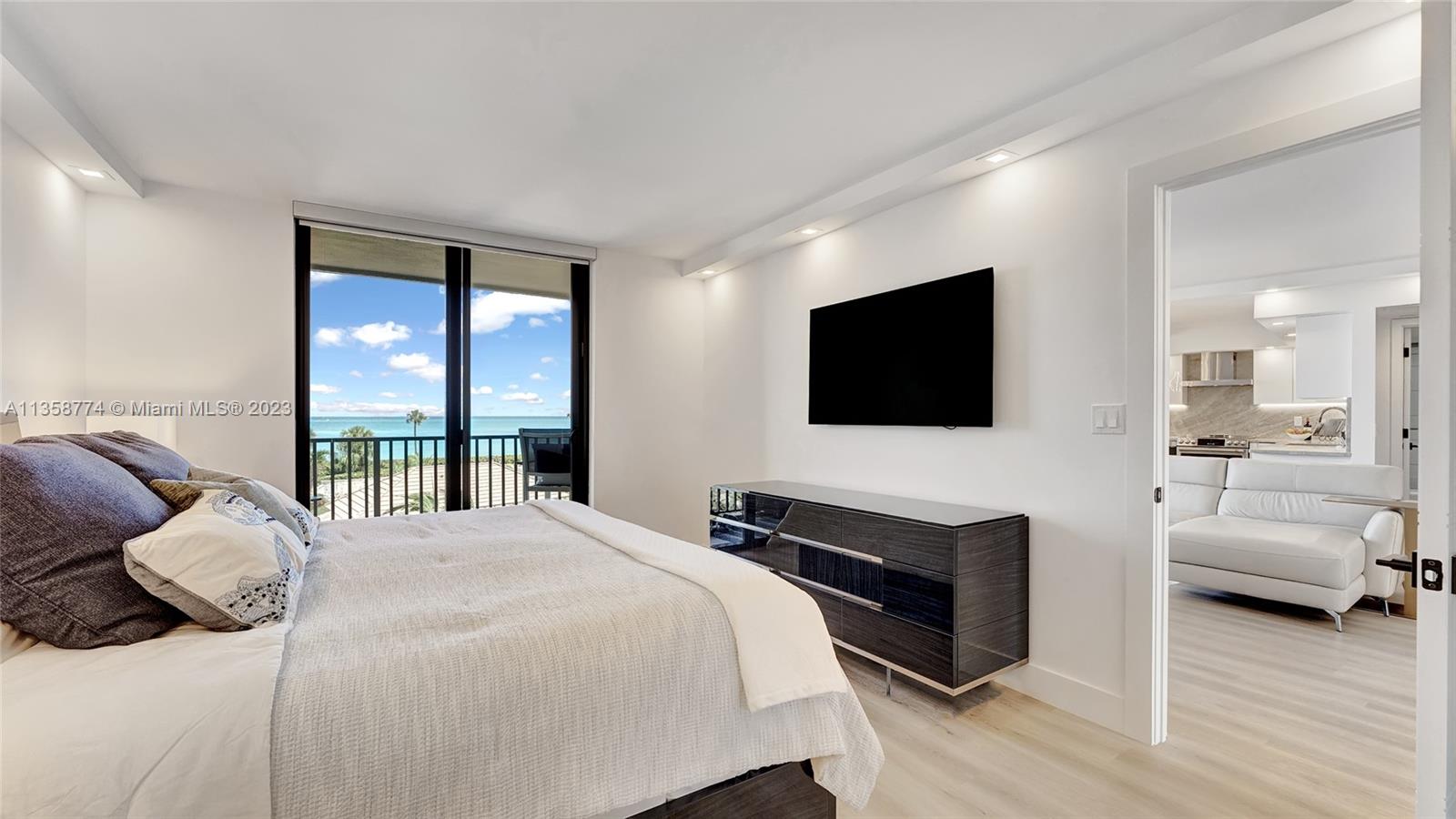 300 Ocean Trail Way, Unit 309 Jupiter, FL 33477 - Photo 15 of 36 a bedroom with a bed and a flat screen tv