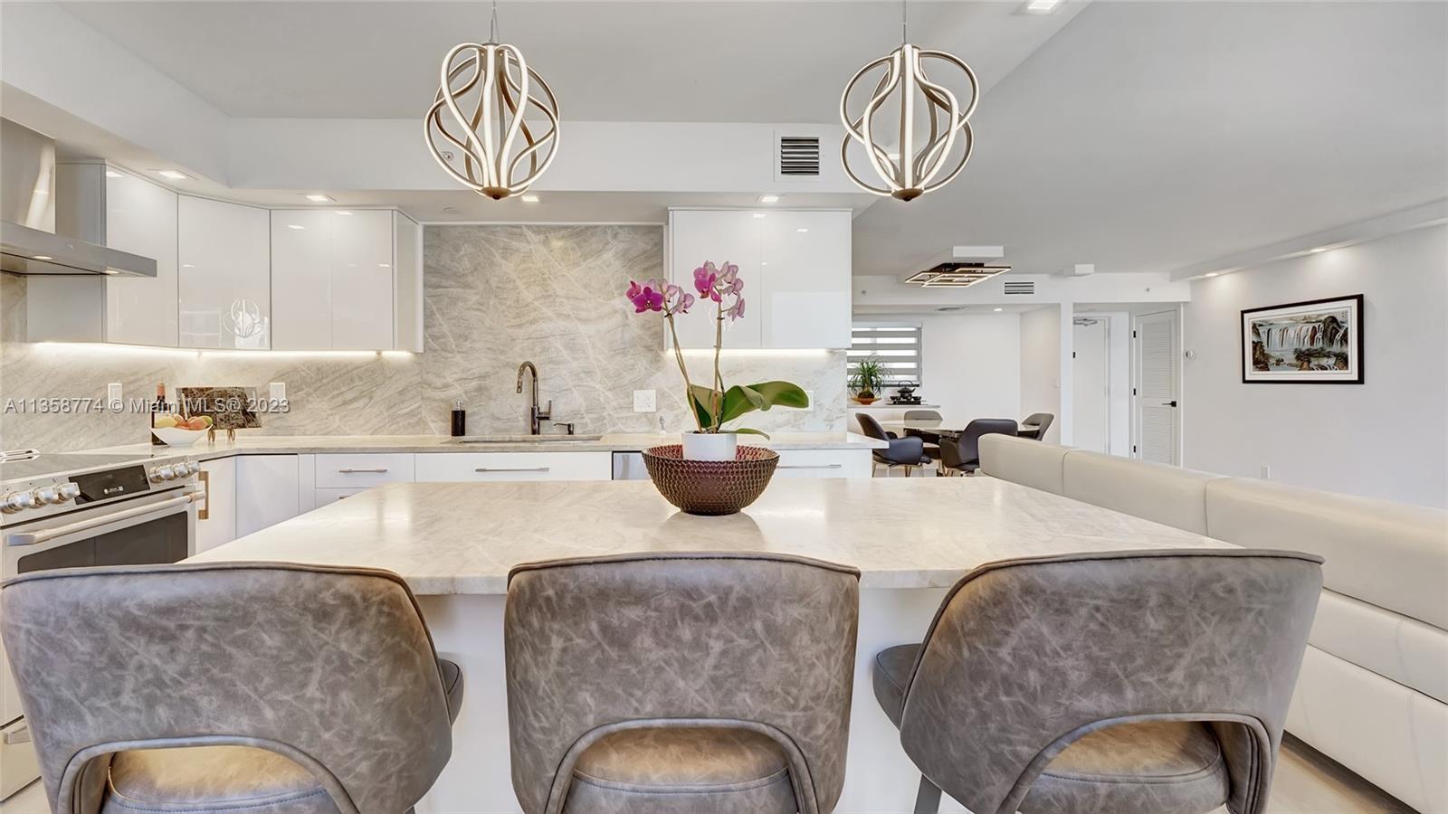 300 Ocean Trail Way, Unit 309 Jupiter, FL 33477 - Photo 6 of 36 a kitchen with stainless steel appliances granite countertop a sink a stove a dining table and chairs with wooden floor