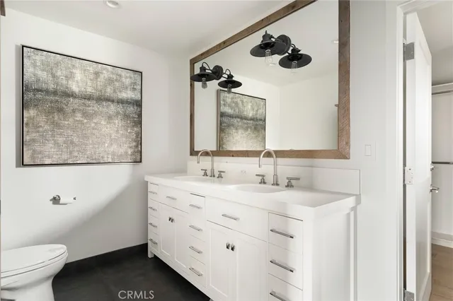 a bathroom with a granite countertop sink mirror vanity and toilet
