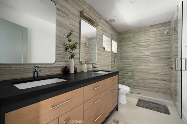 a bathroom with a granite countertop sink toilet and mirror