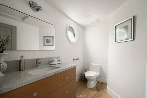 a bathroom with a granite countertop toilet sink and mirror