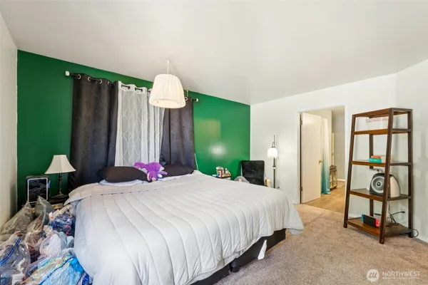 a bedroom with a bed mirror and a window