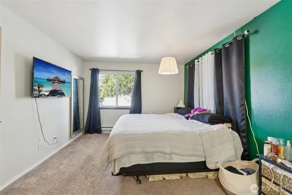 a bedroom with a bed dresser and a window