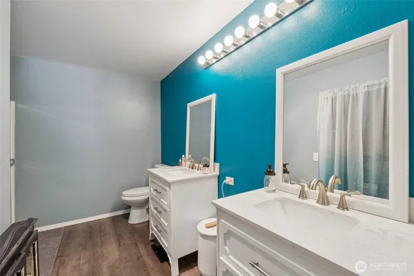 a bathroom with a sink a toilet and mirror