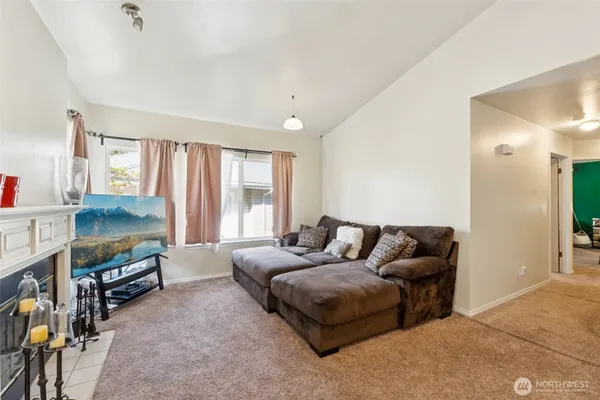 a living room with furniture a flat screen tv and a window