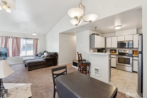 a living room with furniture kitchen and a chandelier