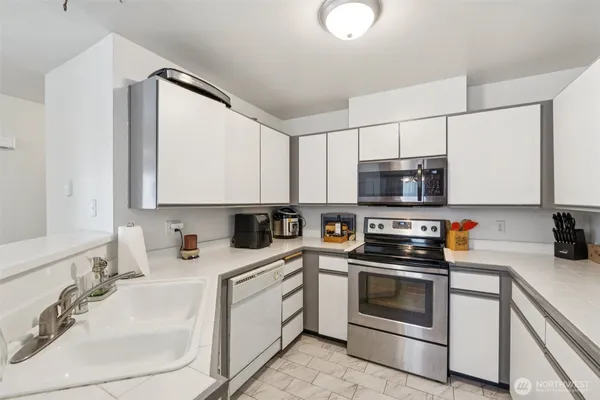 a kitchen with stainless steel appliances a sink stove and microwave