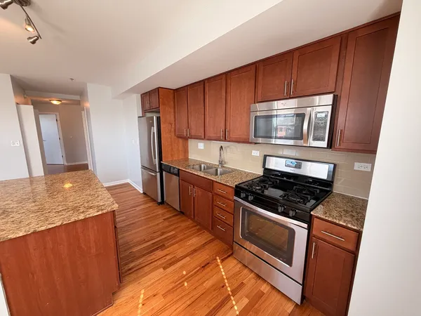 a kitchen with granite countertop wooden cabinets and stainless steel appliances