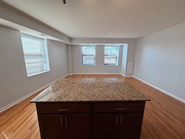 a view of kitchen with granite countertop cabinets and window