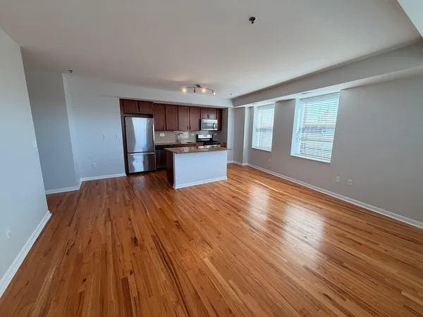 a view of a kitchen with wooden floor and electronic appliances
