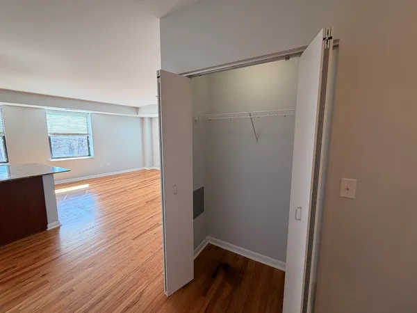 a view of walk in closet with wooden floor