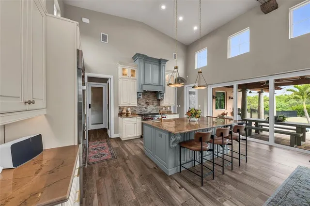a large kitchen with stainless steel appliances granite countertop a lot of counter space and a dining table