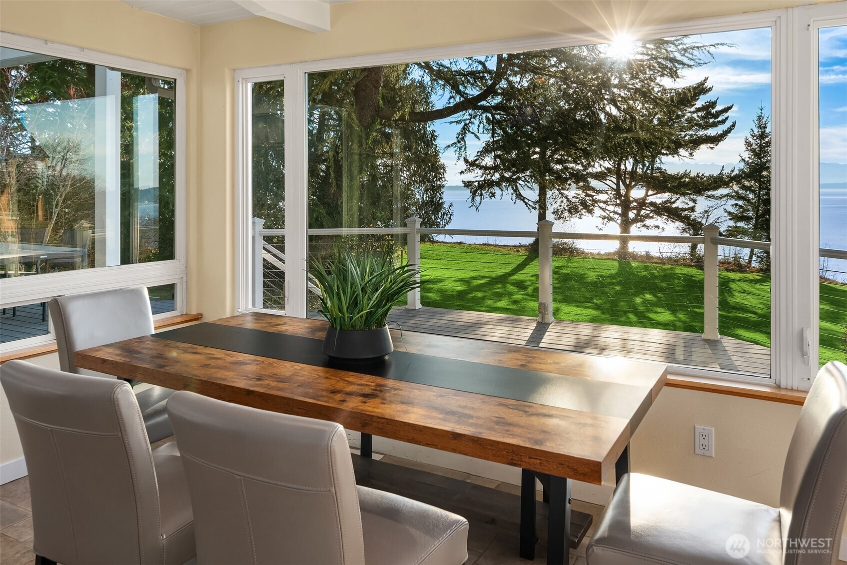 6790 Sills Road Clinton, WA 98236 - Photo 11 of 40 a dining table with a potted plant and a large window with outer view